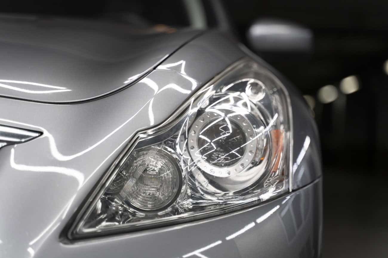 Close-up of car headlight with PPF protection during XPEL detailing.