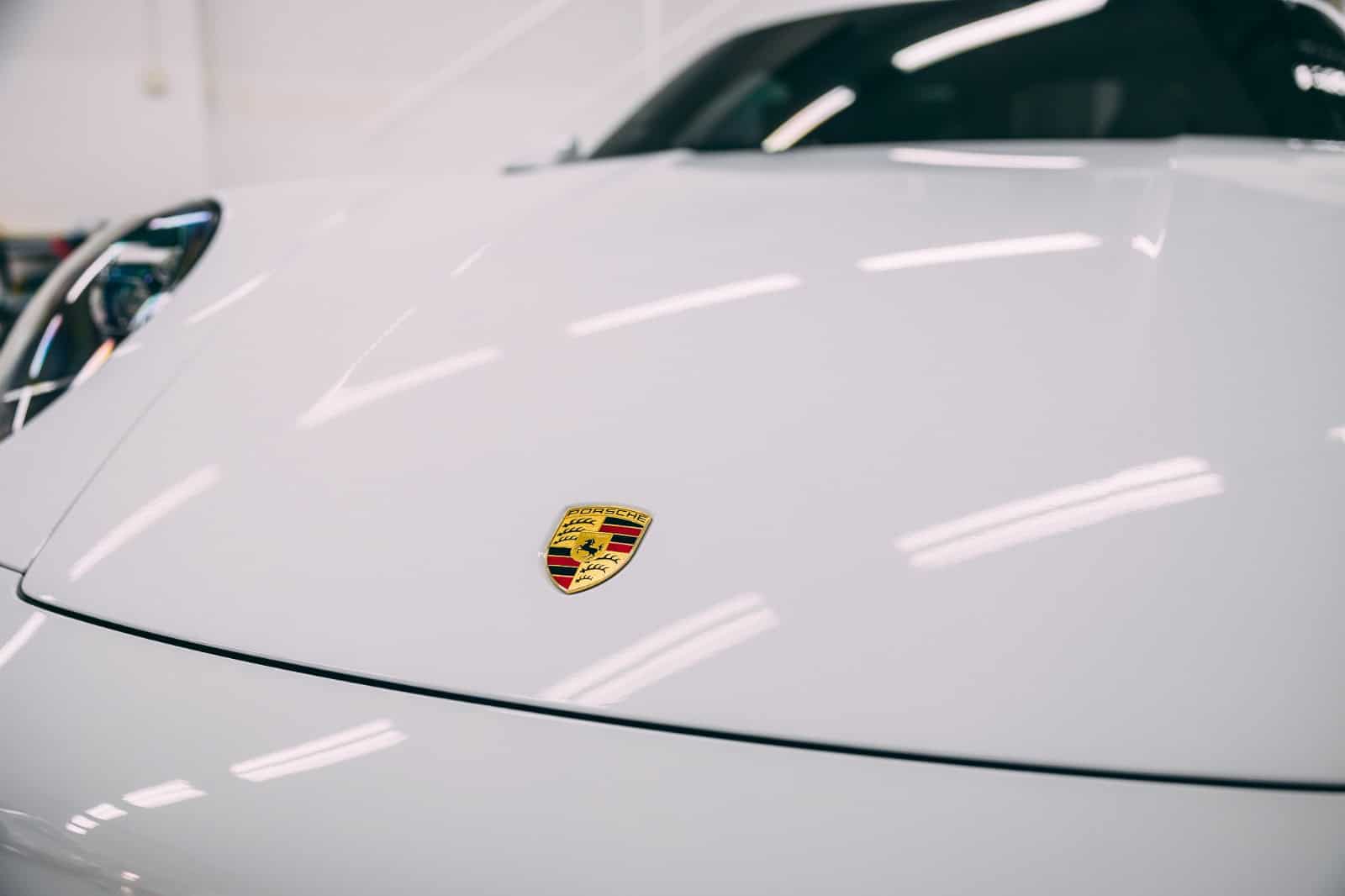 Close-up of Porsche hood with logo during pre-PPF installation process.