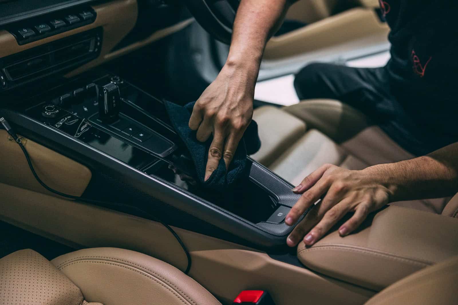 Technician applying protective coating to car interior for detailing and protection.