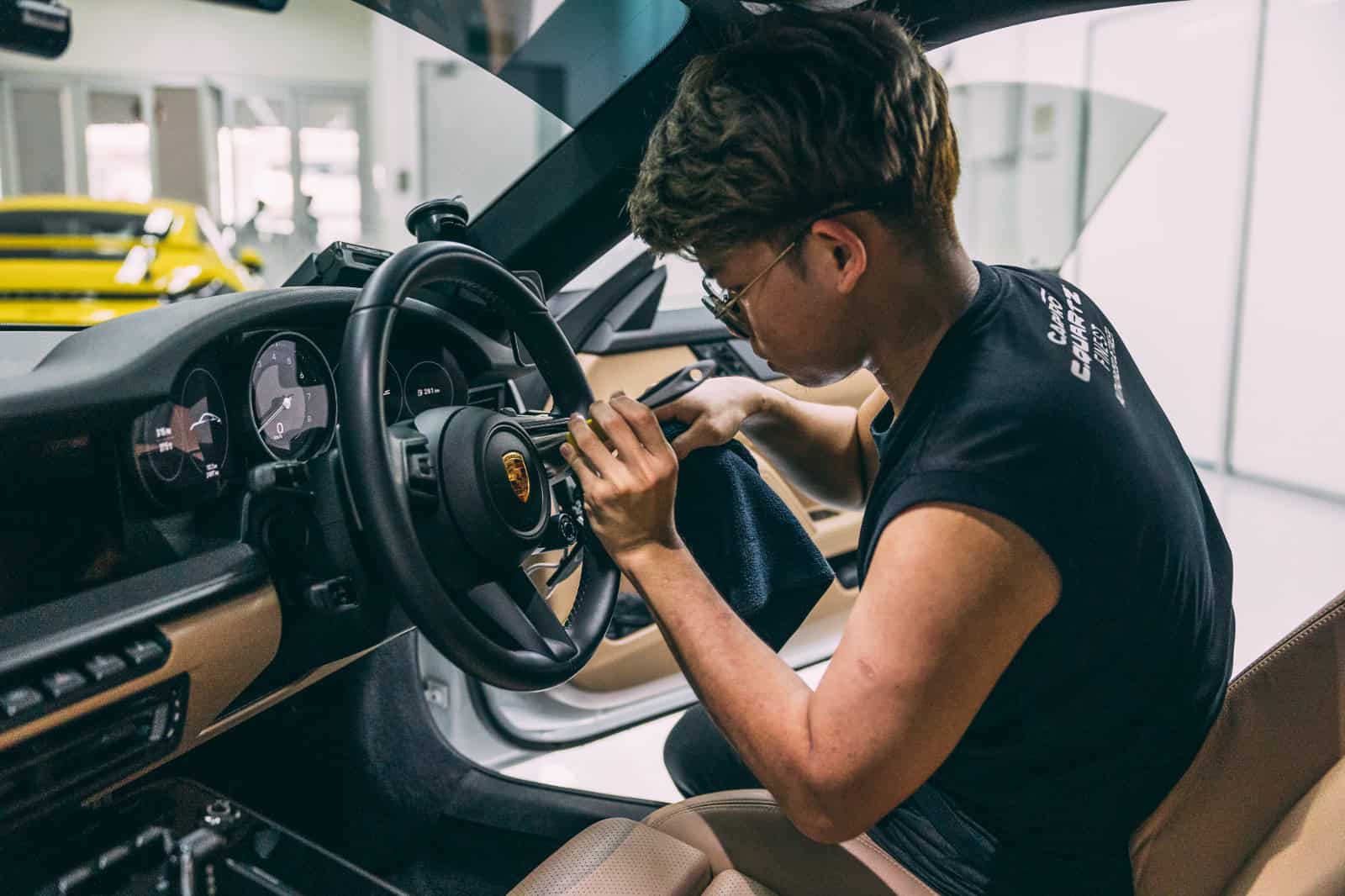 Car detailing technician applying PPF on vehicle interior.