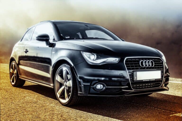 Black Audi hatchback car on road, sleek and modern design.
