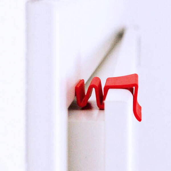 Detailliertes Bild eines roten ClipUp Türspalts und Türpuffers, ideal zur Optimierung der Türschließung und zum Schutz vor Zugluft.