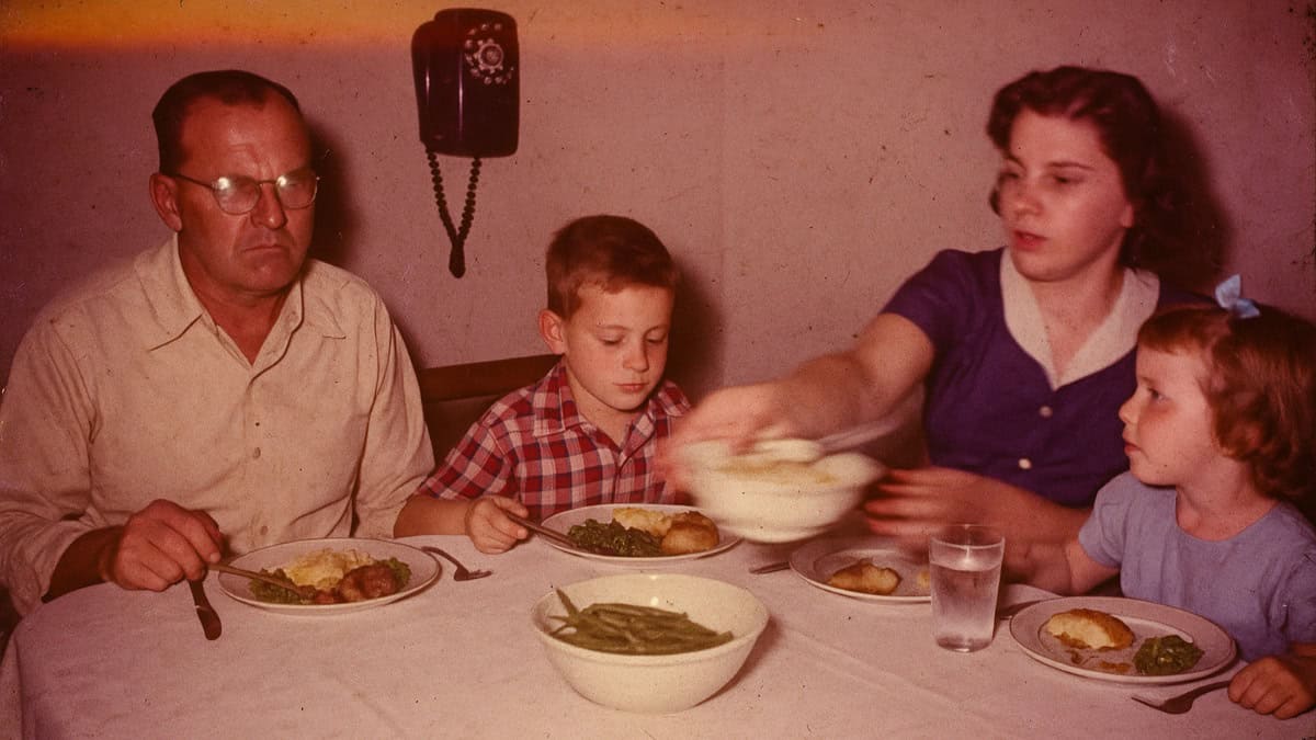 A vintage dining scene illustrating the 1950s rule against phone calls during meals.