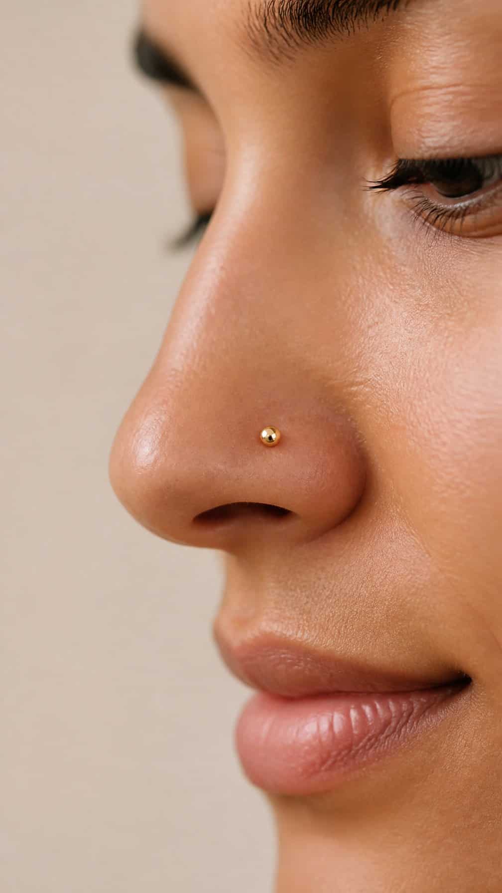 Close-up of a person wearing a small gold nostril stud.