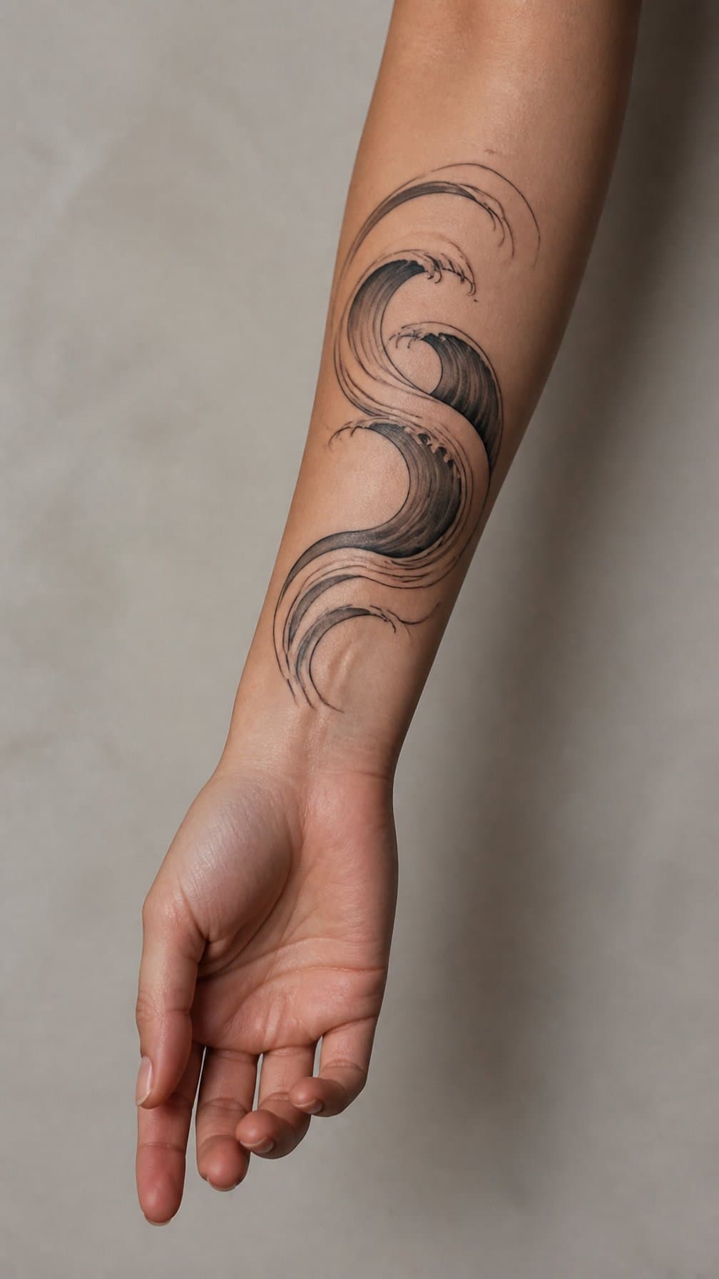 A woman’s forearm displays a flowing abstract wave tattoo against a neutral background.