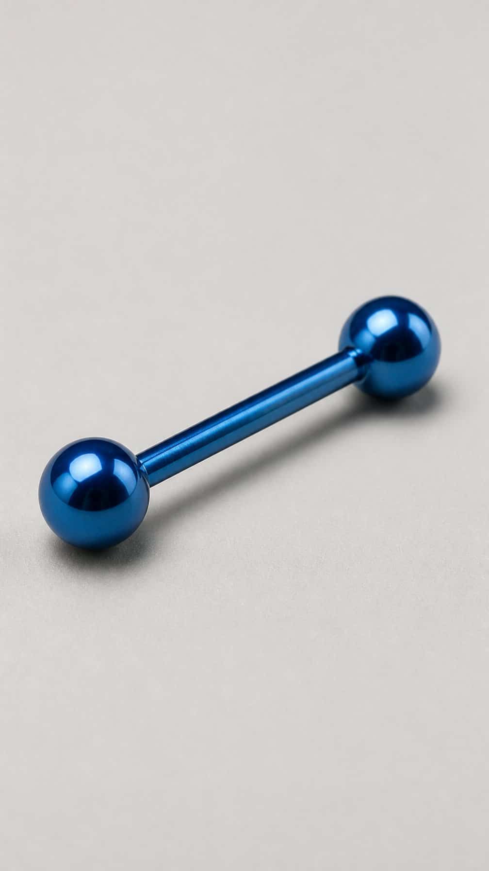 An anodized blue titanium industrial barbell piercing displayed against a neutral background.