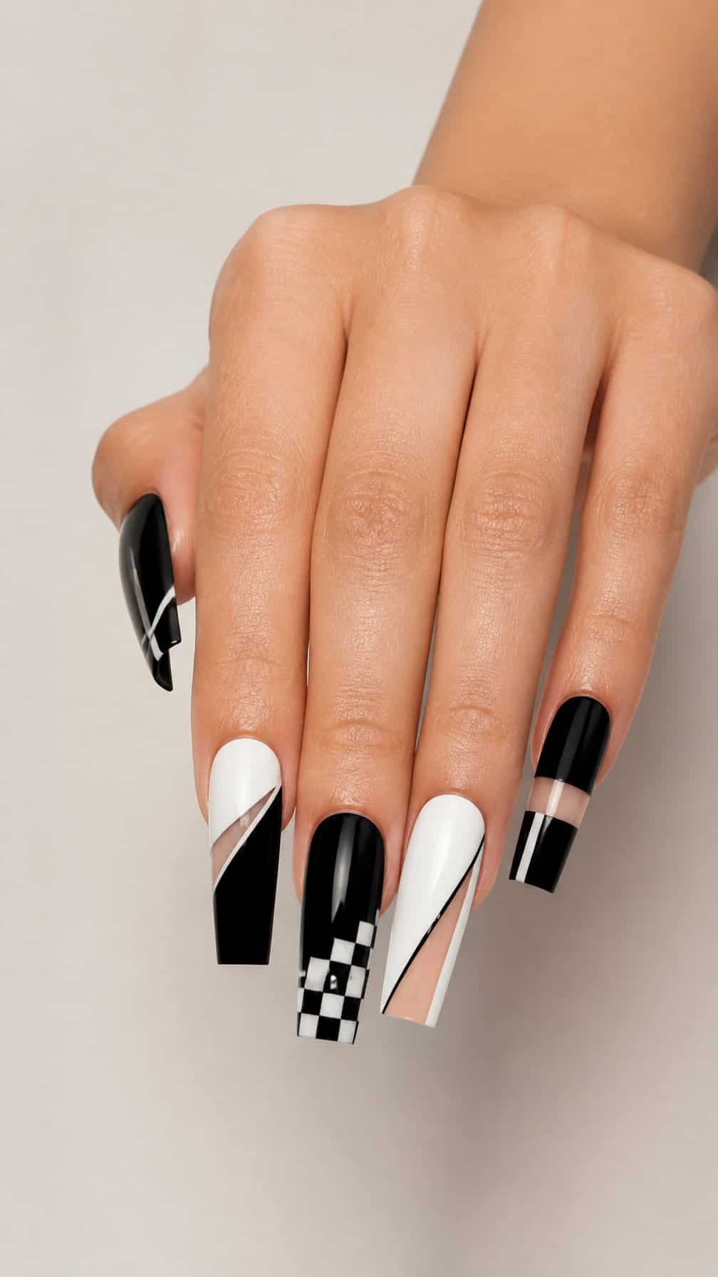 A hand displaying long black-and-white geometric coffin-shaped nails.