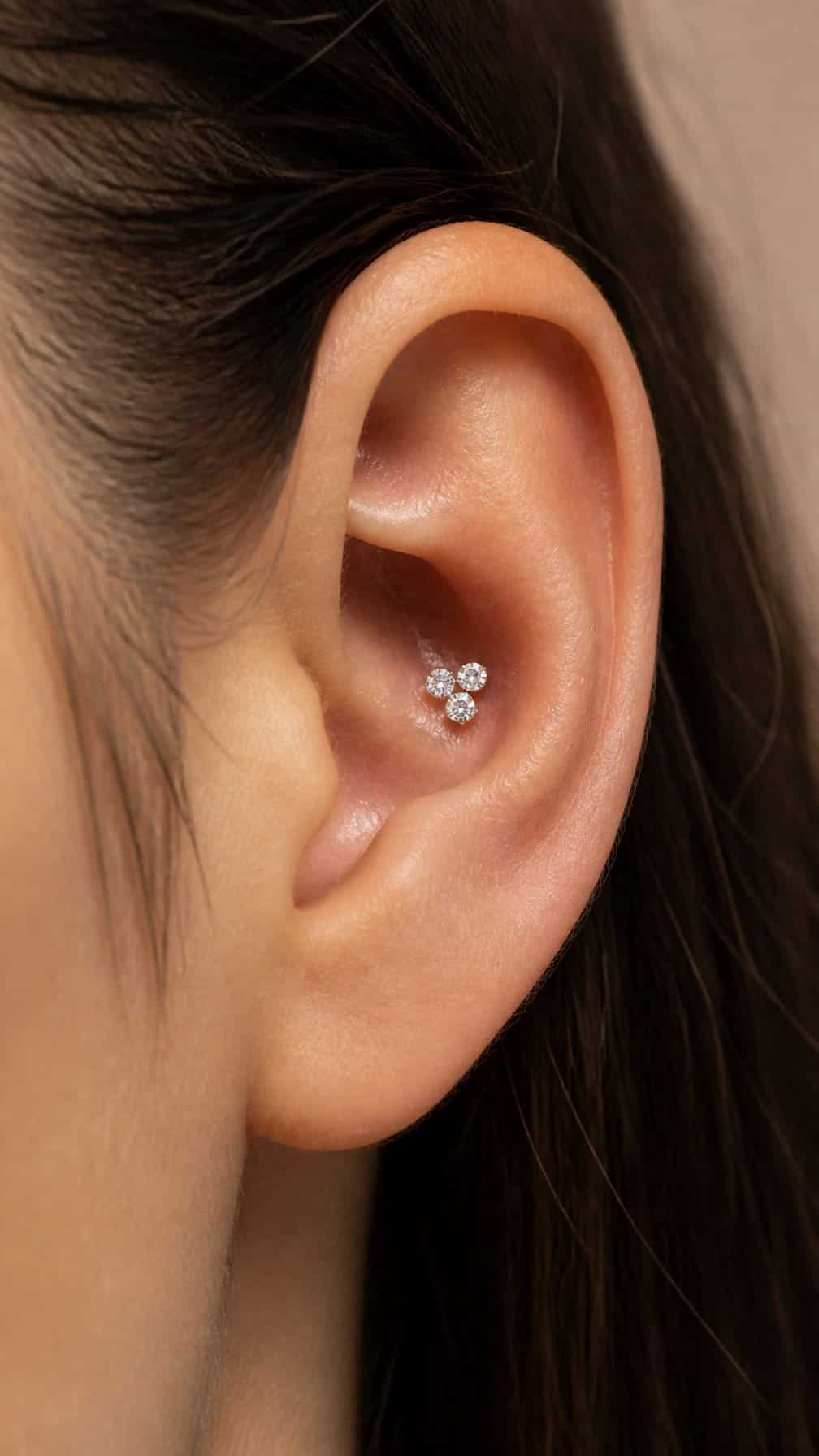 Close-up of an ear wearing a clustered diamond conch piercing.