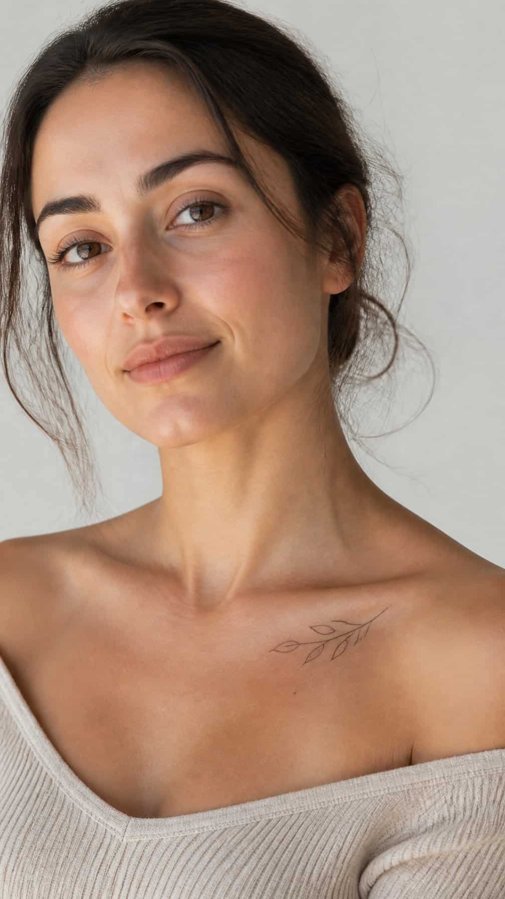 Woman showing a small delicate tattoo along her collarbone.