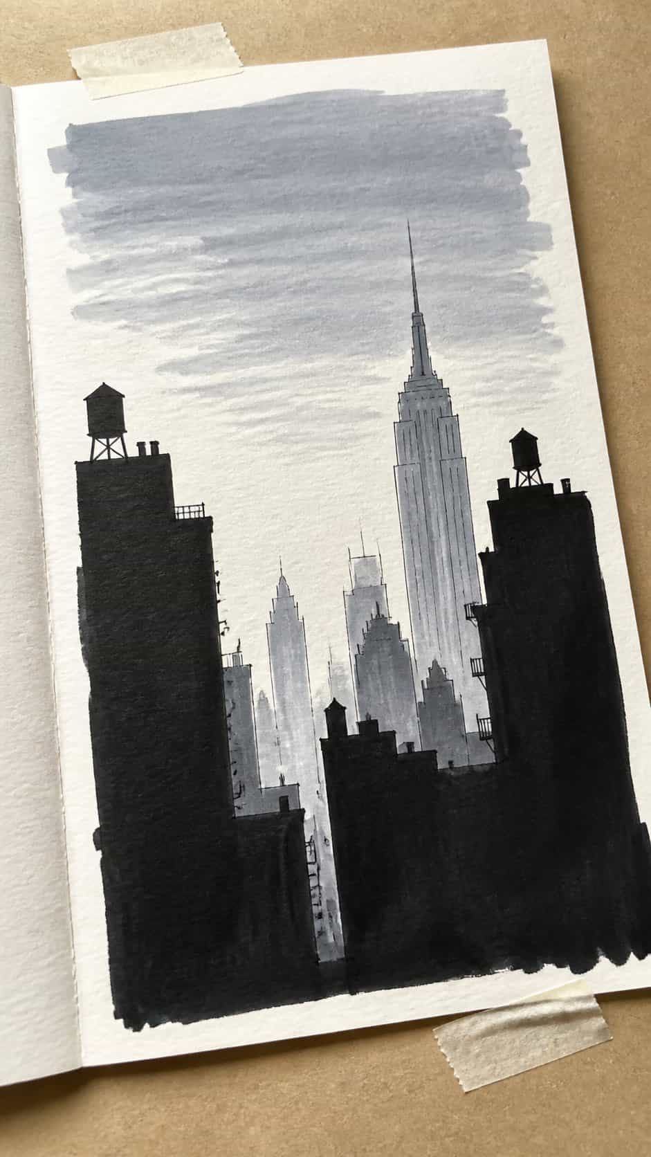 Hand-drawn cityscape silhouettes in marker drawing on textured paper, shown in a gentle oblique desk view that shows paper tooth and — study 1