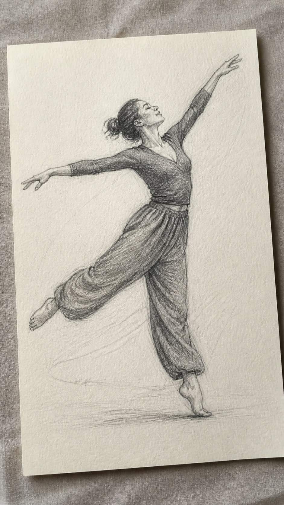 Hand-drawn joyful dance movement in graphite drawing on textured paper, shown in a gentle oblique desk view that shows paper tooth and — study 1