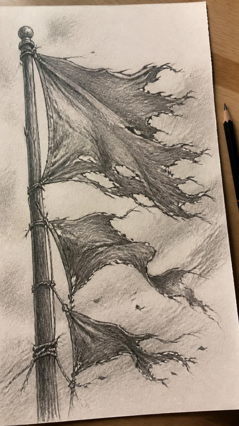 30 Grunge Drawing Ideas for Real Depth and Texture 15 Hand-drawn tattered flags in graphite drawing on textured paper, shown in a close overhead crop — study 2