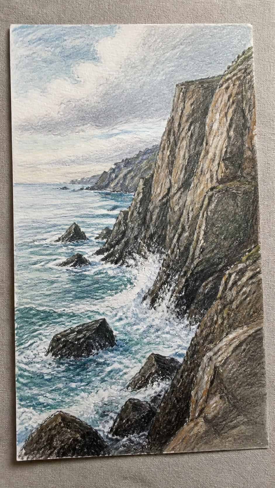 Hand-drawn rocky coastal cliffs in colored-pencil and gouache drawing on textured paper, shown in a gentle oblique desk view that — study 2