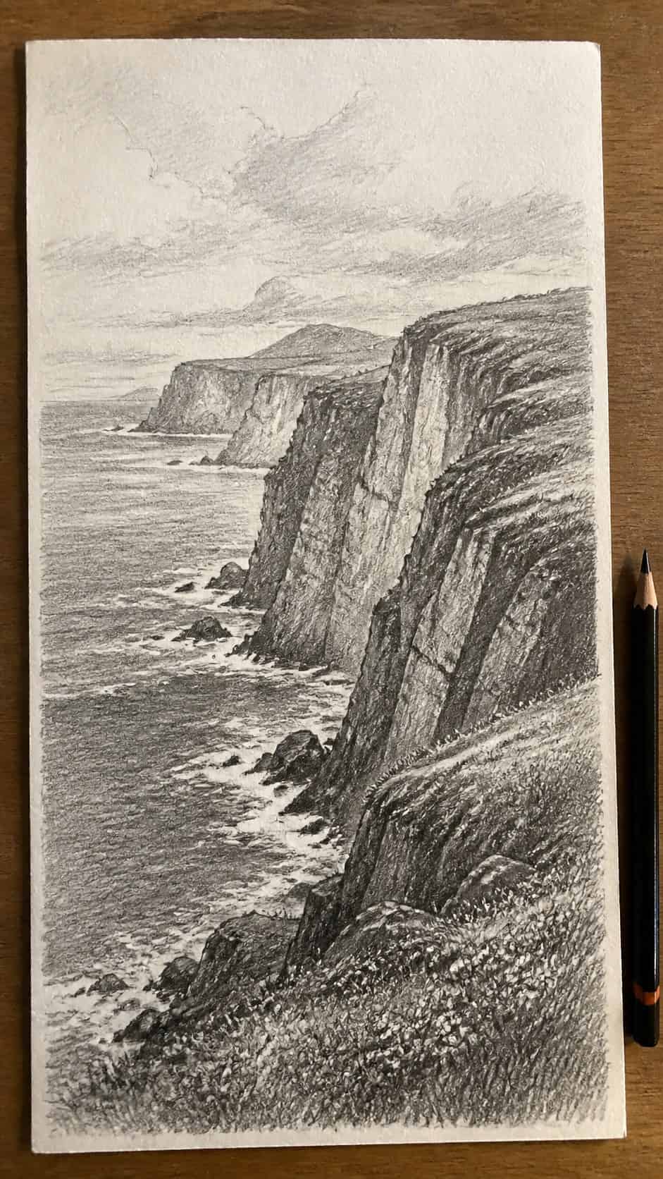 17 Nature Drawing Concepts to Inspire Your Next Sketch 16 Hand-drawn coastal cliffside in graphite drawing on textured paper, shown in a straight overhead view — study 3