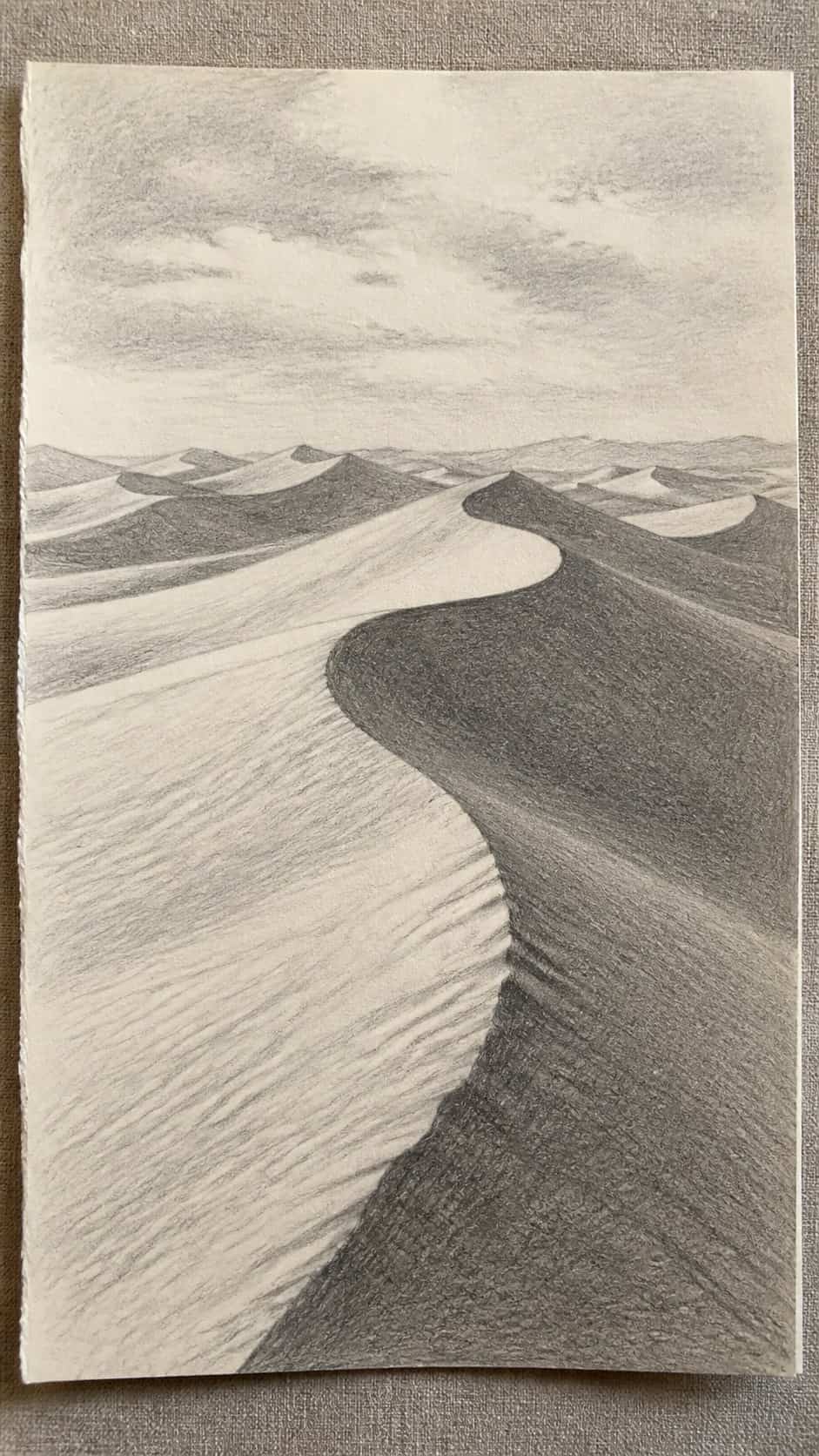 17 Nature Drawing Concepts to Inspire Your Next Sketch 19 Hand-drawn desert dunes in graphite drawing on textured paper, shown in a close overhead crop — study 1