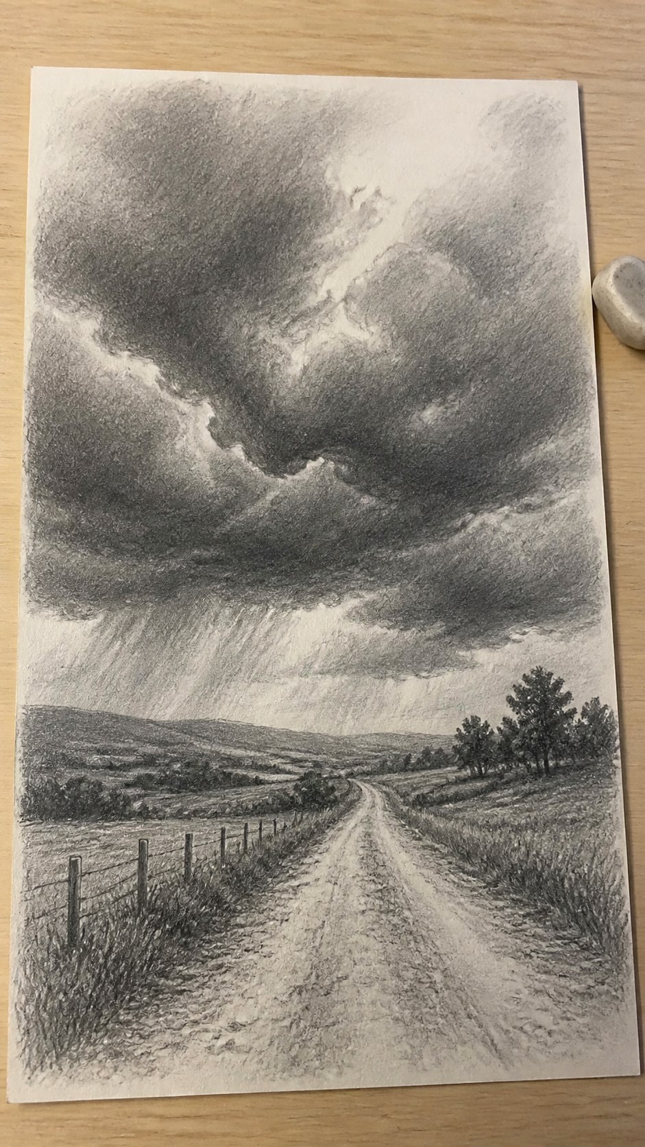 17 Nature Drawing Concepts to Inspire Your Next Sketch 27 Hand-drawn stormy skies in graphite drawing on textured paper, shown in a slightly off-center overhead composition, like an artist — study 2