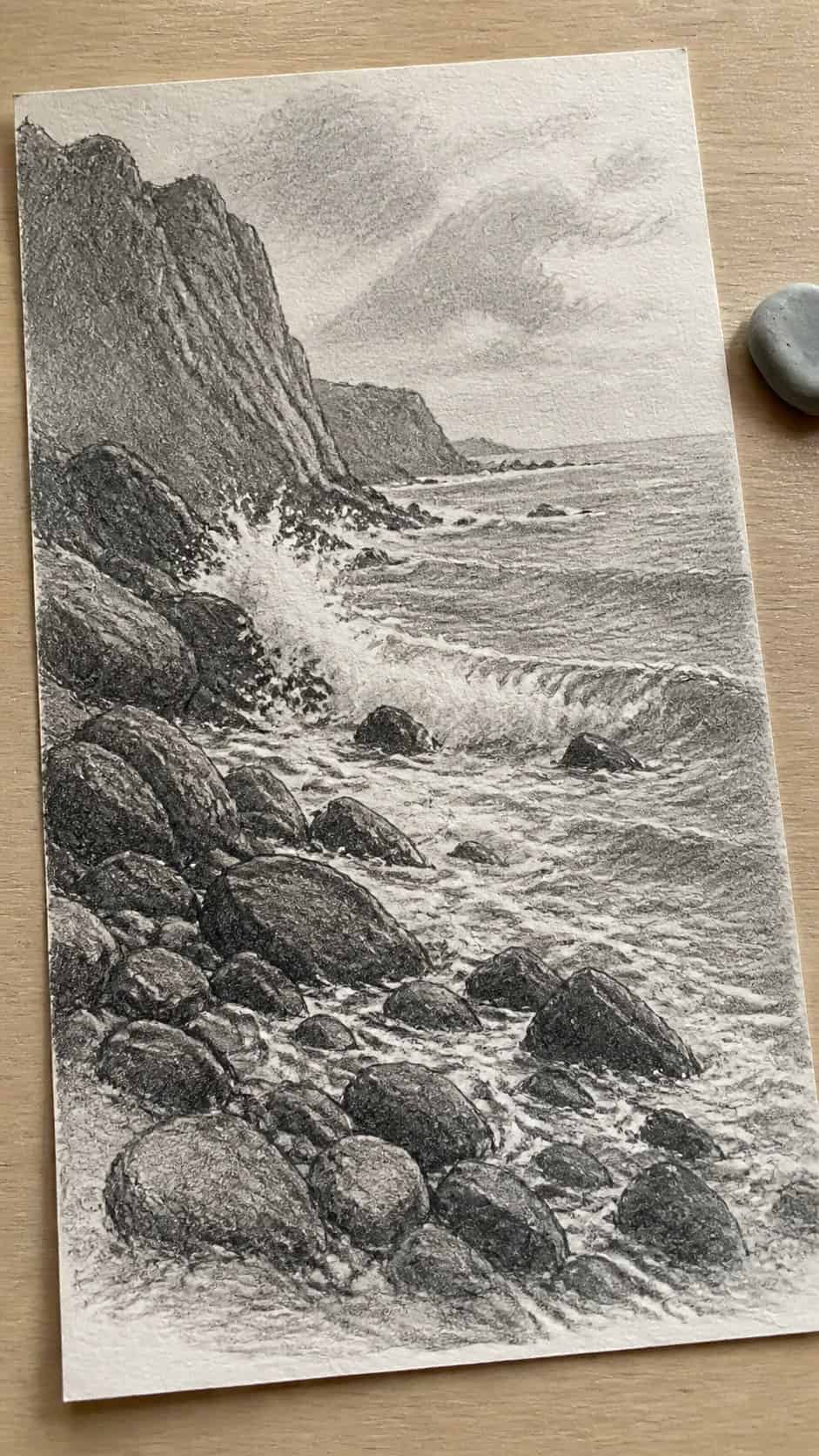 17 Nature Drawing Concepts to Inspire Your Next Sketch 43 Hand-drawn rocky shoreline in graphite drawing on textured paper, shown in a gentle oblique desk view that shows paper tooth and — study 3