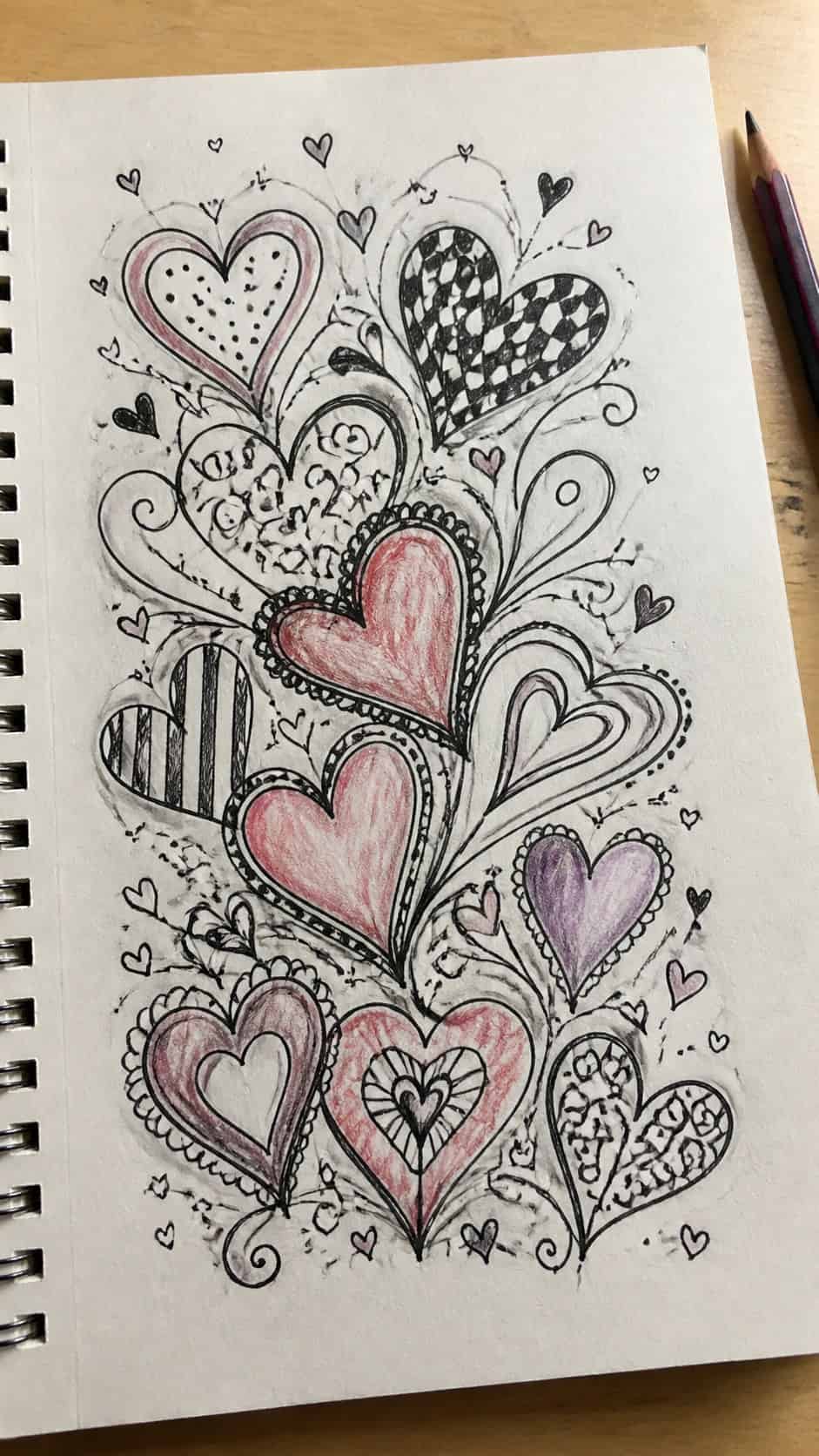 Unlock Your Heart: 18 Romantic Drawing Ideas That Capture Love Perfectly 36 Hand-drawn artistic heart doodles in ink and colored-pencil drawing on textured paper, shown in a slightly off-center overhead — study 1