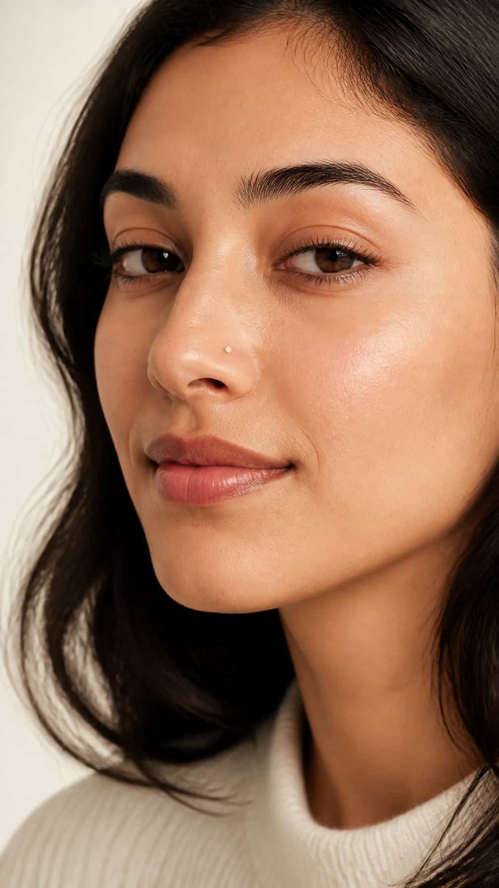Close-up portrait of a woman wearing a small flat-back nostril stud.