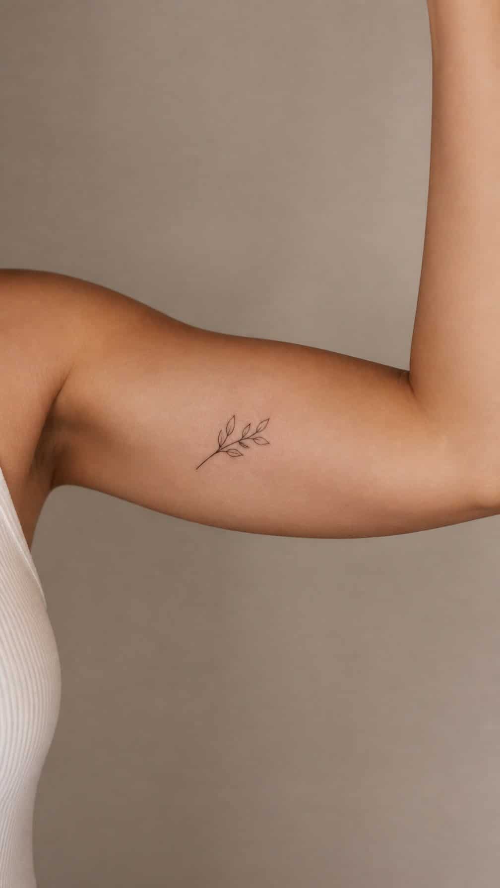 Close-up of an adult’s inner upper arm with a small minimalist tattoo.