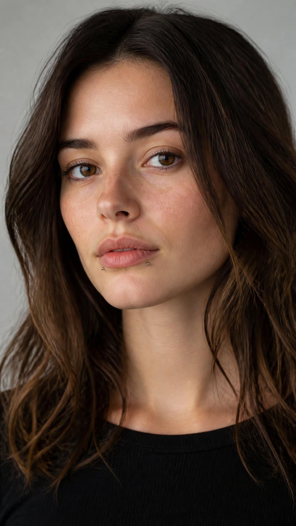 Close-up portrait of a person wearing two small symmetrical studs beside the lower lip.