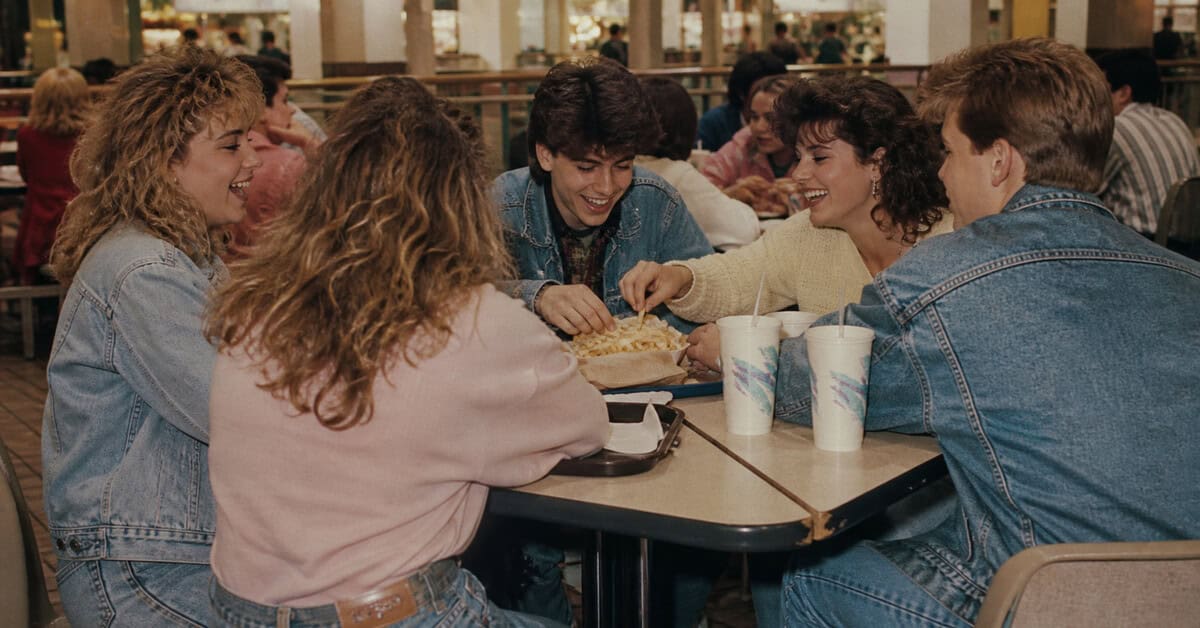 What Kids Did at the Mall in the Eighties That Just Doesn't Happen Anymore 6 Teen friends sharing fries and talking at a 1980s mall food court