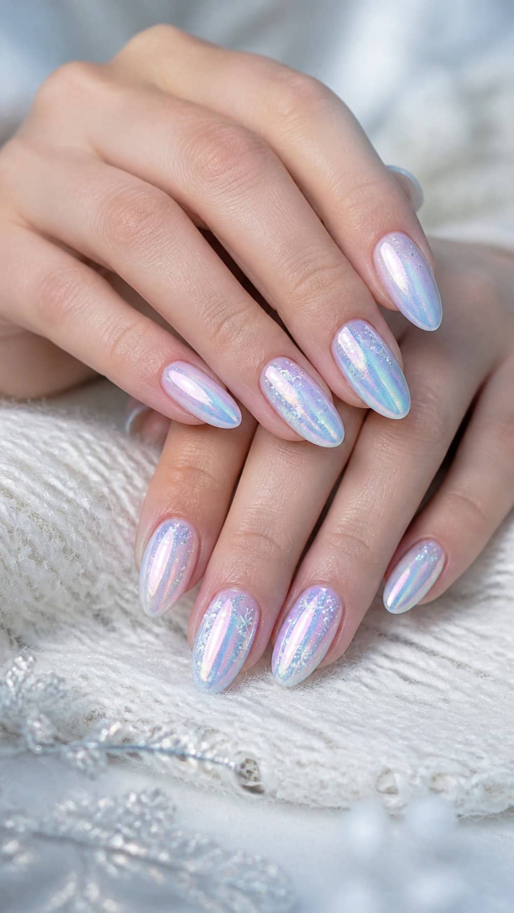 Close-up of hands with iridescent opal nails decorated with delicate snowflake accents.