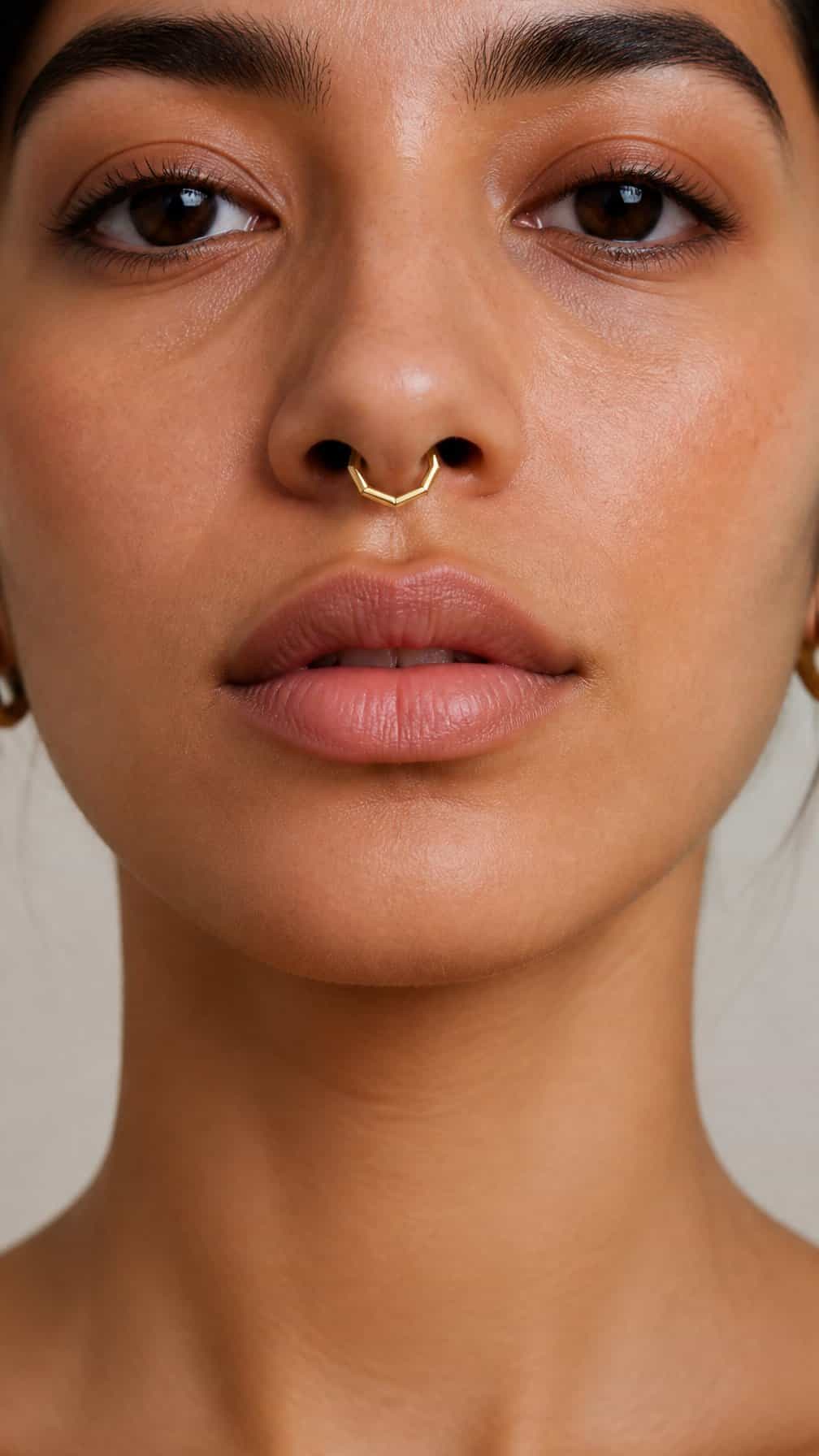 Close-up portrait of a person wearing a geometric septum clicker.