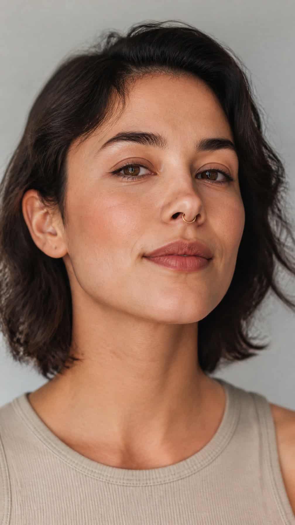 Close-up portrait of an adult wearing a small septum ring correctly positioned beneath the nasal cartilage.
