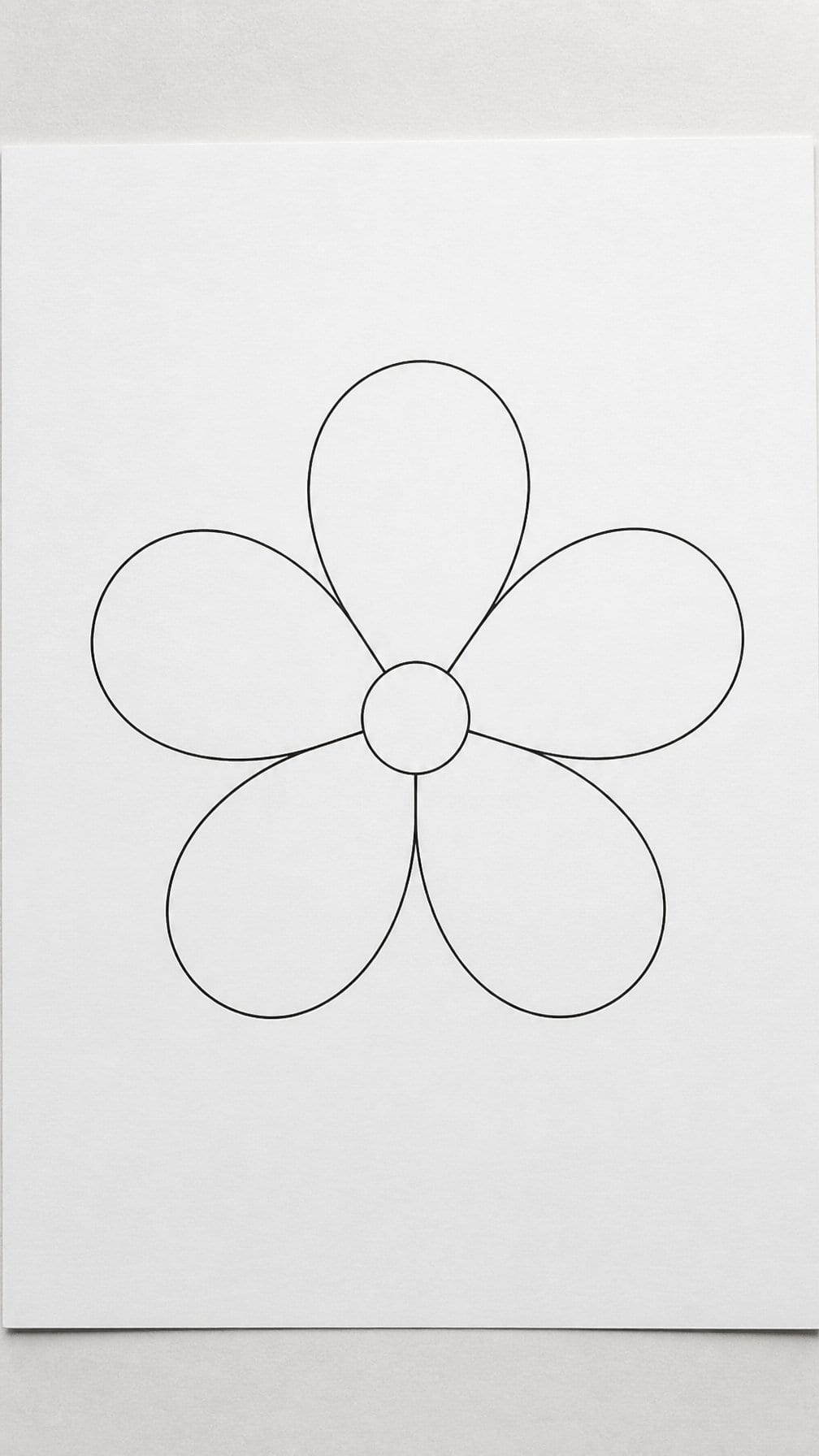 A simple five-petal daisy outline drawn on white paper.