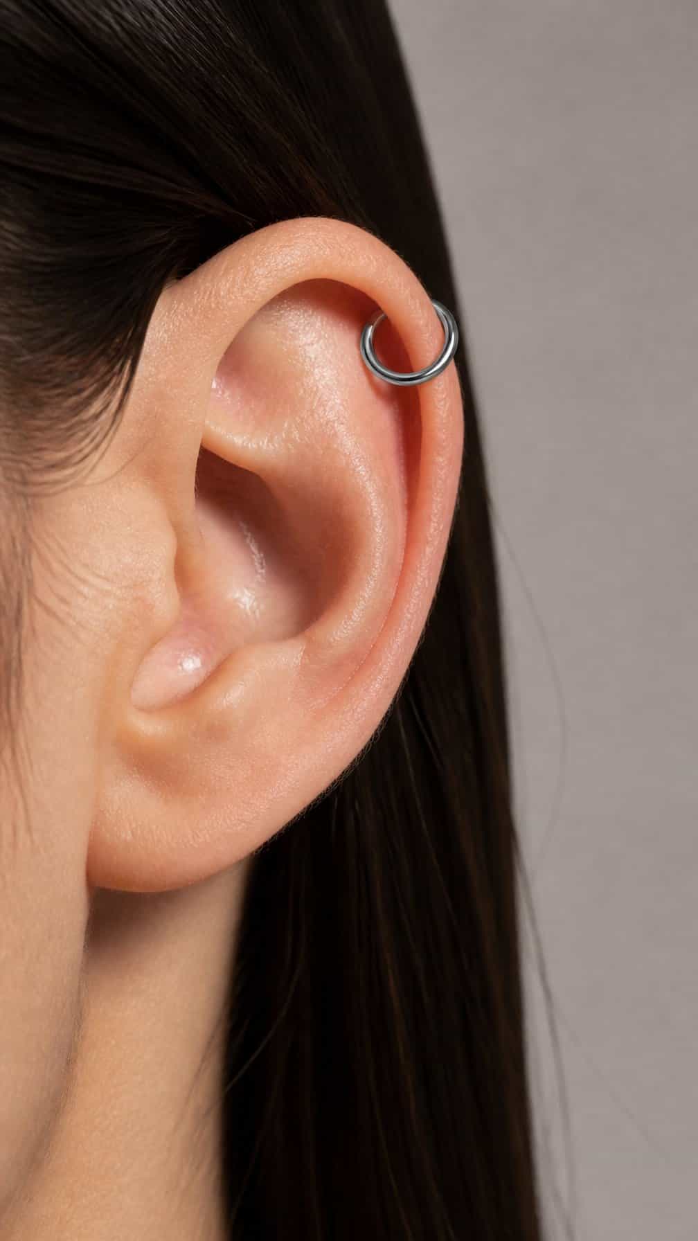 Close-up of an ear with a single seamless hoop in the upper cartilage.