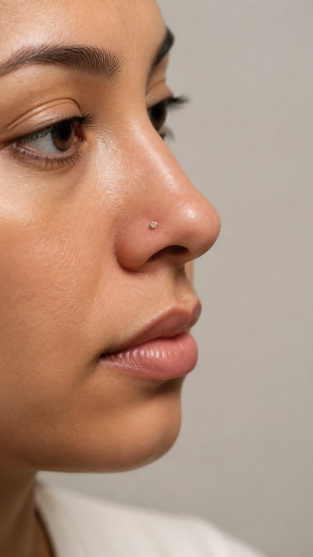 Close-up of a person with a tiny gemstone stud in one nostril.