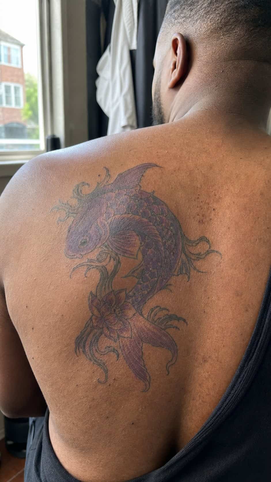 From Samurai to Dragons: 19 Stunning Japanese Tattoo Ideas for Men 5 Healed koi fish tattoo on a adult man's upper back, photographed in a natural straight-on close view, a touch off-center like a quick — study 1