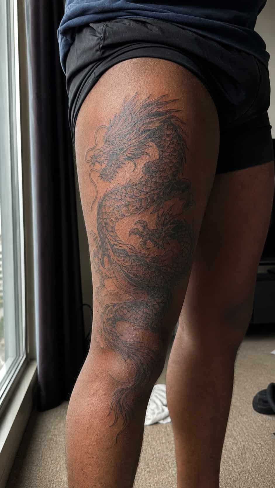 From Samurai to Dragons: 19 Stunning Japanese Tattoo Ideas for Men 7 Healed dragon tattoo on a adult man's outer thigh, photographed in a natural gentle side angle that clearly shows how the ink wraps — study 1