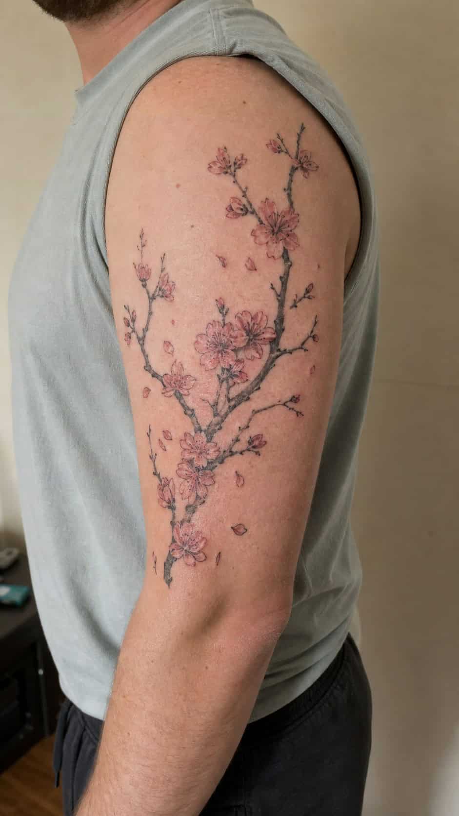From Samurai to Dragons: 19 Stunning Japanese Tattoo Ideas for Men 11 Healed cherry blossoms tattoo on a adult man's outer upper arm, photographed in a natural waist-height candid close-up — study 2