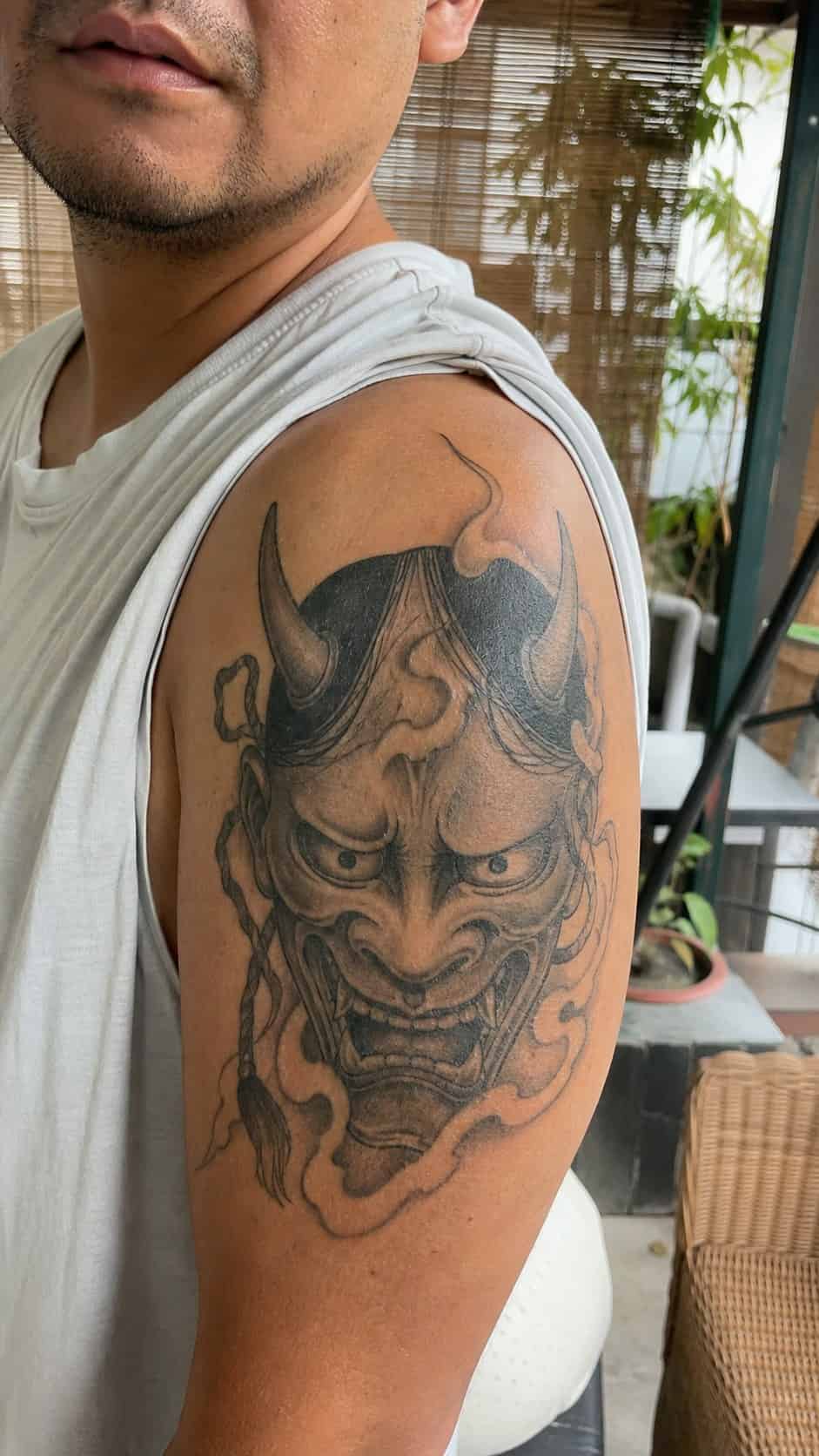From Samurai to Dragons: 19 Stunning Japanese Tattoo Ideas for Men 17 Healed hannya mask tattoo on a adult man's shoulder, photographed in a natural casual close three-quarter view — study 2