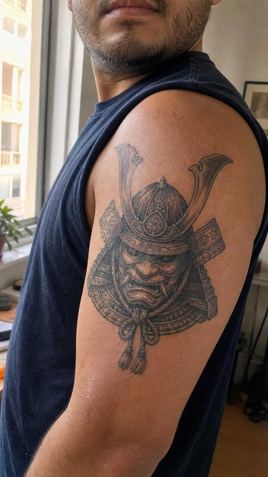 From Samurai to Dragons: 19 Stunning Japanese Tattoo Ideas for Men 29 Healed samurai helmet (kabuto) tattoo on a adult man's outer upper arm, photographed in a natural waist-height candid close-up — study 3