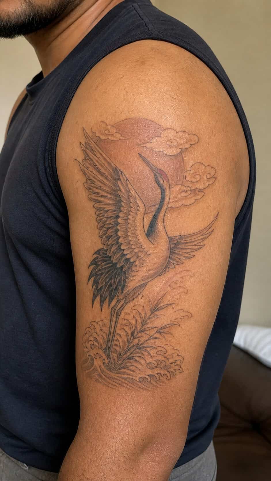 From Samurai to Dragons: 19 Stunning Japanese Tattoo Ideas for Men 30 Healed crane tattoo on a adult man's outer upper arm, photographed in a natural slightly elevated close view — study 1