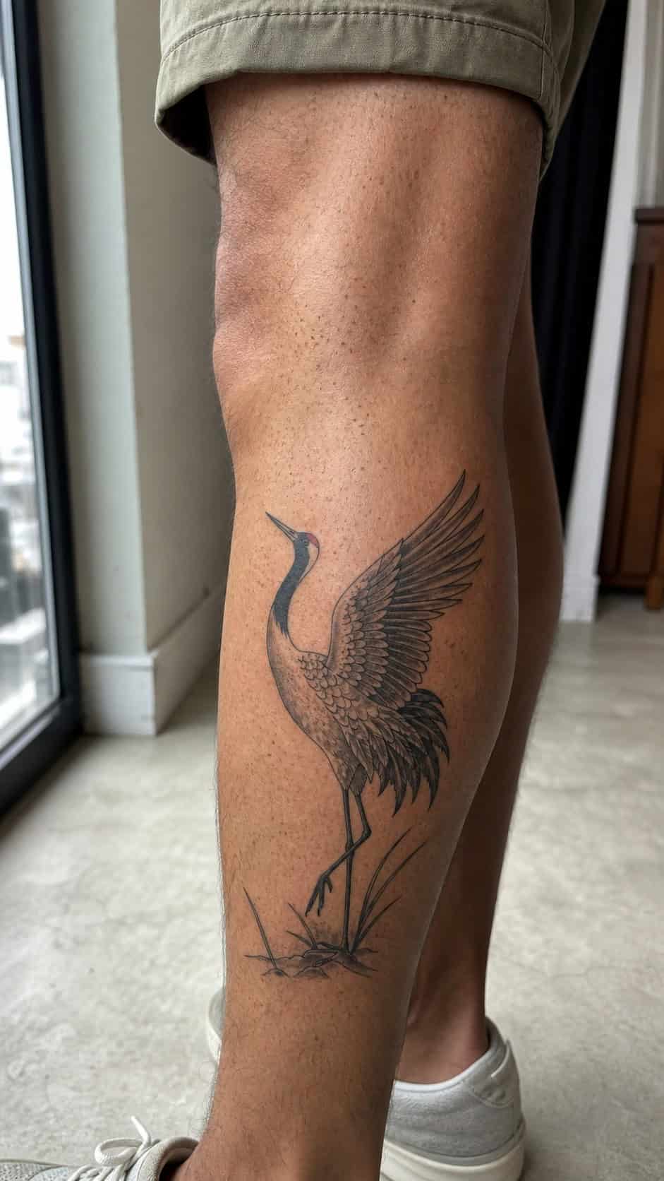 From Samurai to Dragons: 19 Stunning Japanese Tattoo Ideas for Men 31 Healed crane tattoo on a adult man's outer calf, photographed in a natural waist-height candid close-up — study 2