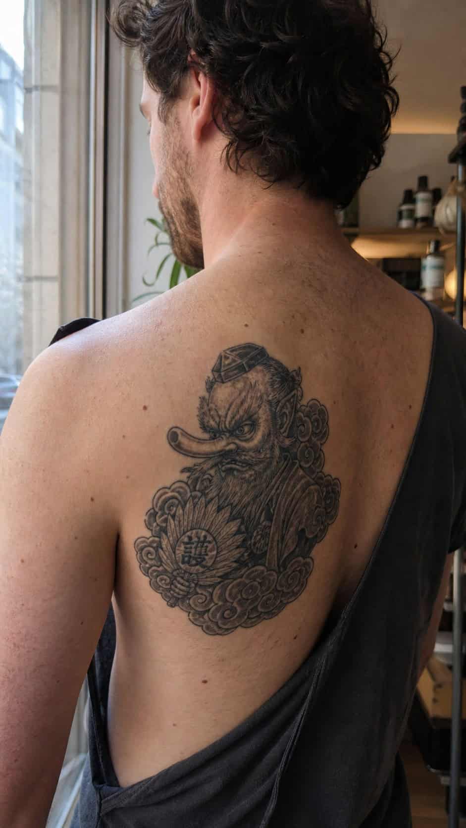 From Samurai to Dragons: 19 Stunning Japanese Tattoo Ideas for Men 32 Healed tengu tattoo on a adult man's upper back, photographed in a natural waist-height candid close-up — study 1