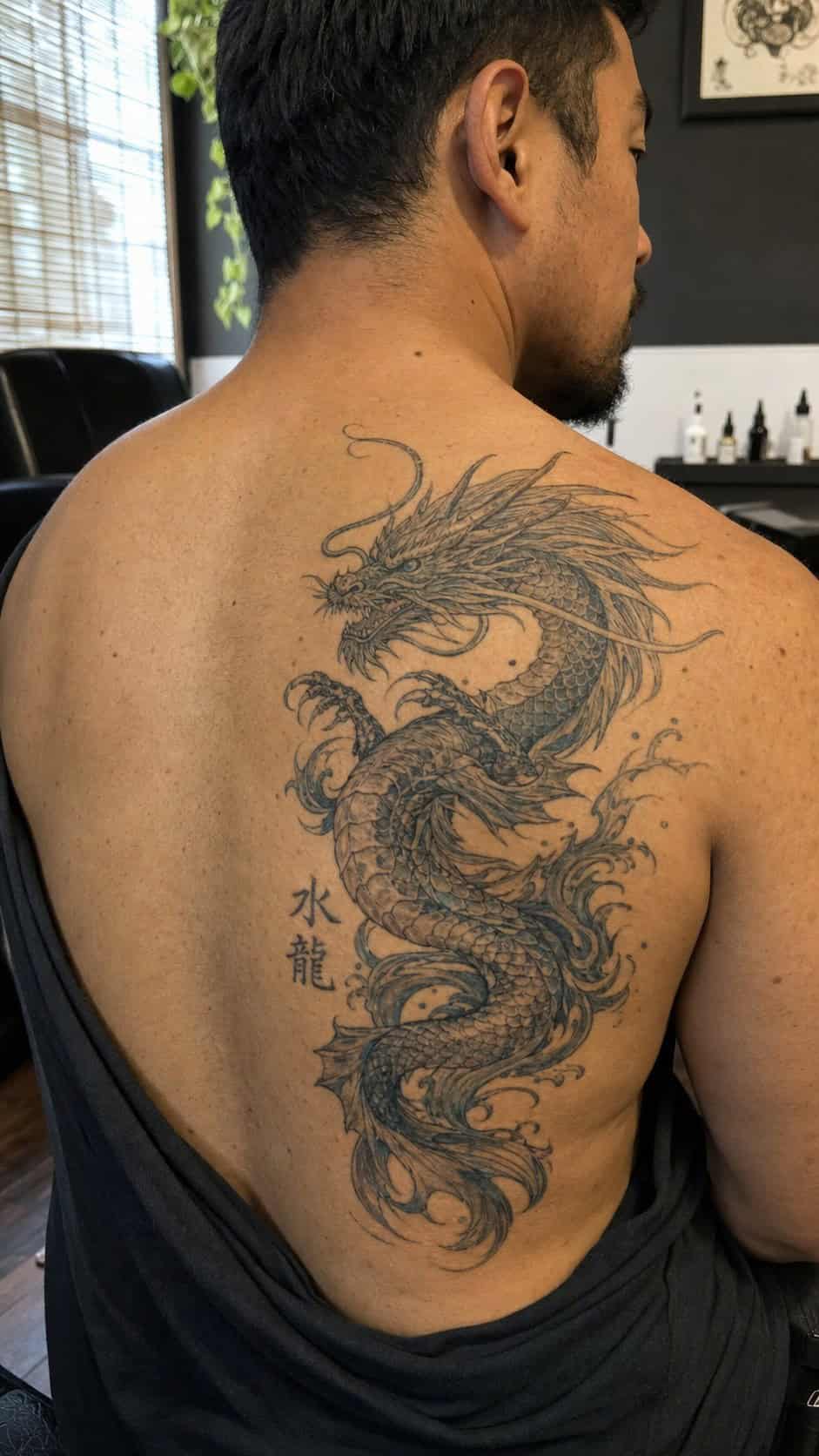 From Samurai to Dragons: 19 Stunning Japanese Tattoo Ideas for Men 42 Healed water dragon (mizuryu) tattoo on a adult man's upper back, photographed in a natural casual close three-quarter view — study 2