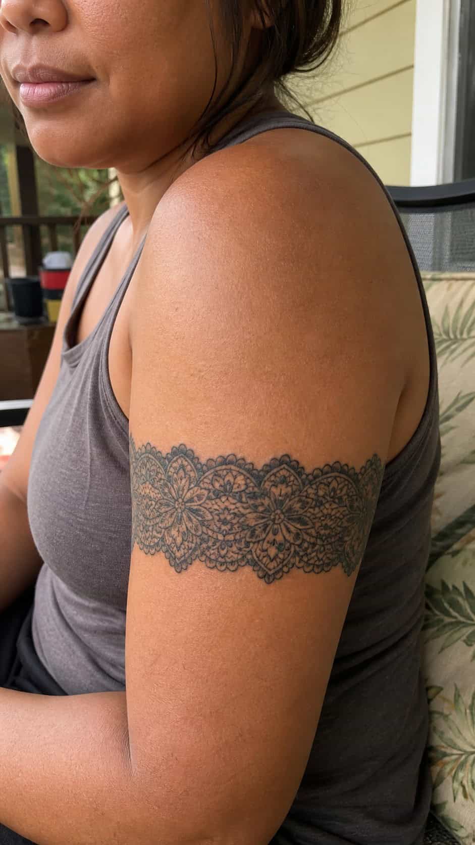 Healed intricate lace band tattoo on a adult woman's shoulder, photographed in a natural waist-height candid close-up — study 3