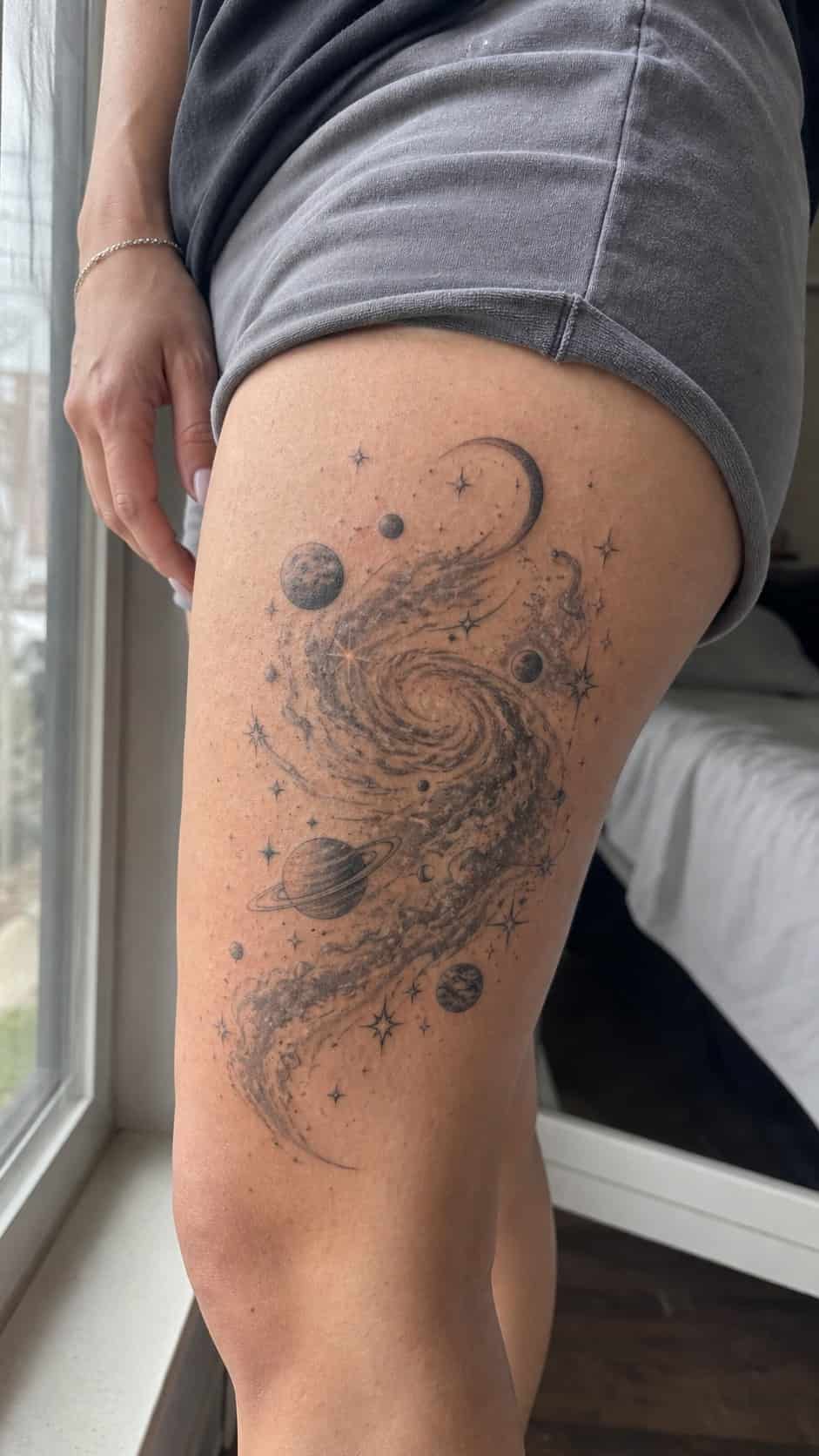 Healed cosmic galaxy scene tattoo on a adult woman's outer thigh, photographed in a natural gentle side angle that clearly shows how — study 2