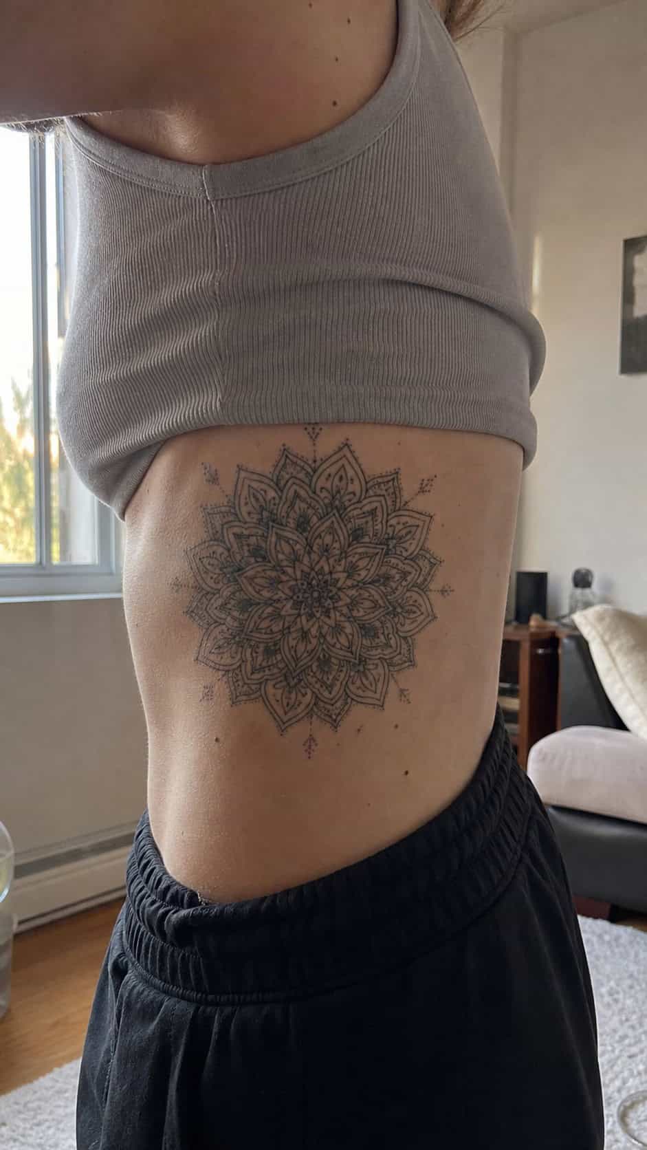 32 Stunning Rib Tattoos for Women 4 Healed intricate mandala tattoo on a adult woman's side ribs, photographed in a natural relaxed documentary crop — study 1