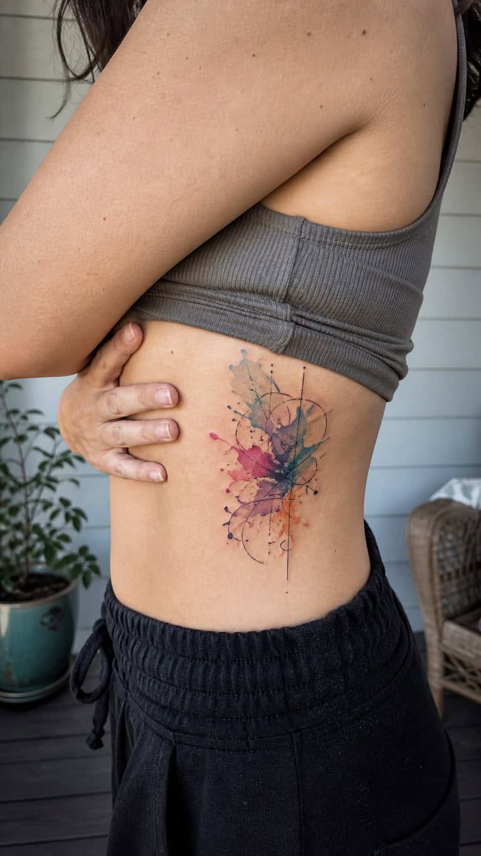 32 Stunning Rib Tattoos for Women 9 Healed abstract watercolor tattoo on a adult woman's side ribs, photographed in a natural waist-height candid close-up — study 2