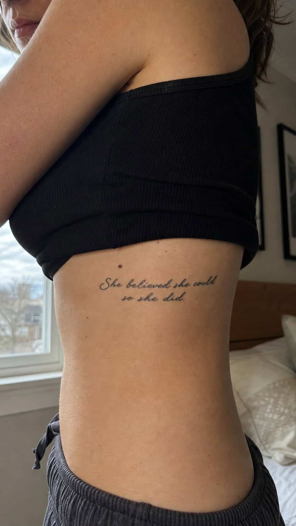 32 Stunning Rib Tattoos for Women 11 Healed script writing tattoo on a adult woman's side ribs, photographed in a natural casual close three-quarter view — study 2