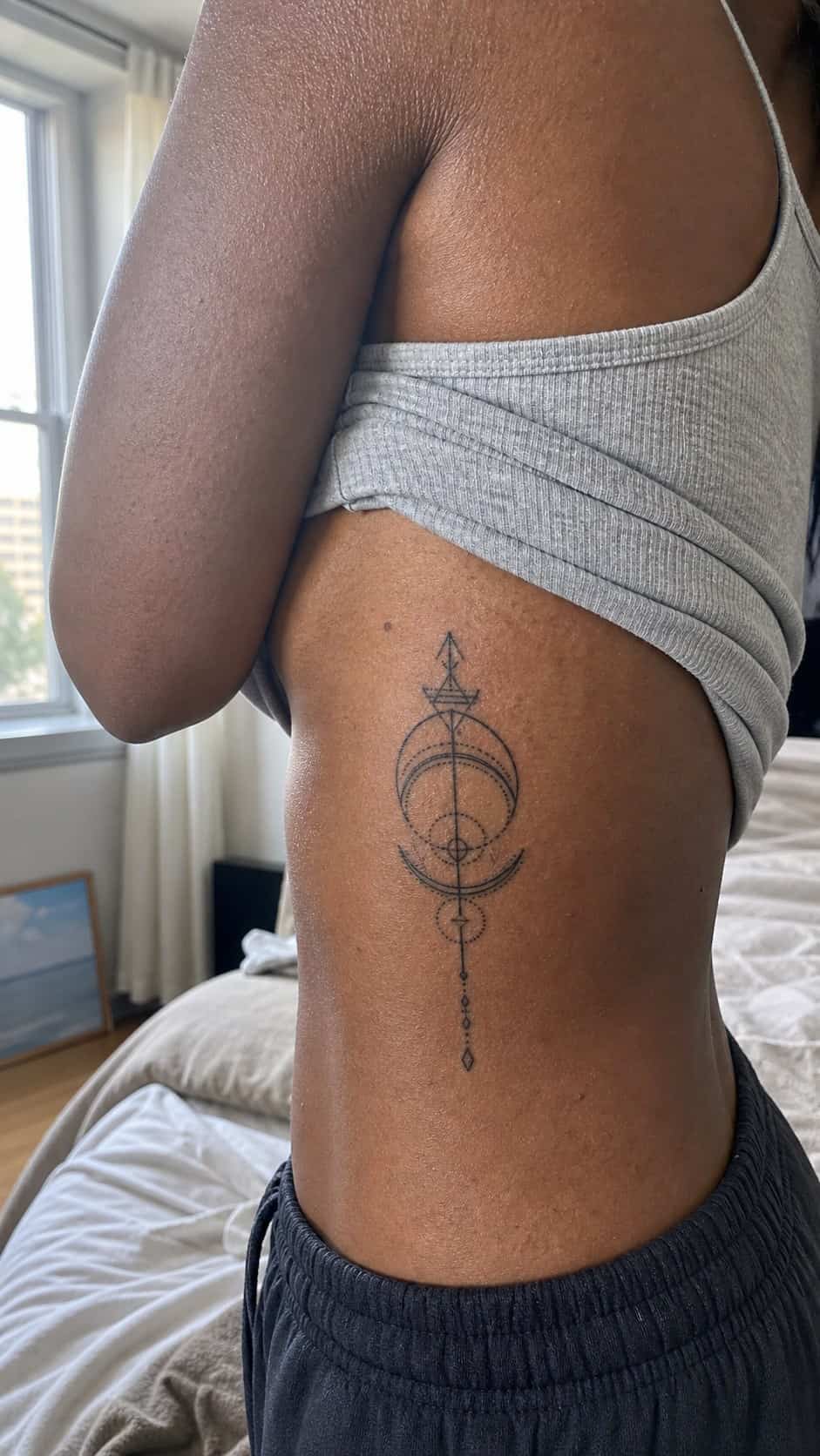 32 Stunning Rib Tattoos for Women 12 Healed geometric patterns tattoo on a adult woman's side ribs, photographed in a natural relaxed documentary crop — study 1