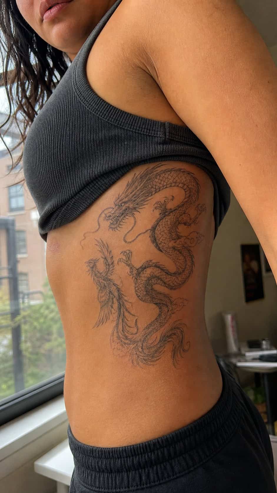 32 Stunning Rib Tattoos for Women 18 Healed mythical creatures tattoo on a adult woman's side ribs, photographed in a natural relaxed documentary crop — study 1