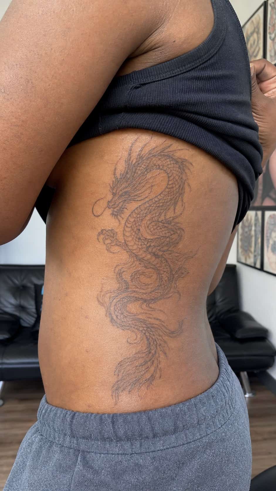 32 Stunning Rib Tattoos for Women 19 Healed mythical creatures tattoo on a adult woman's side ribs, photographed in a natural casual close three-quarter view — study 2