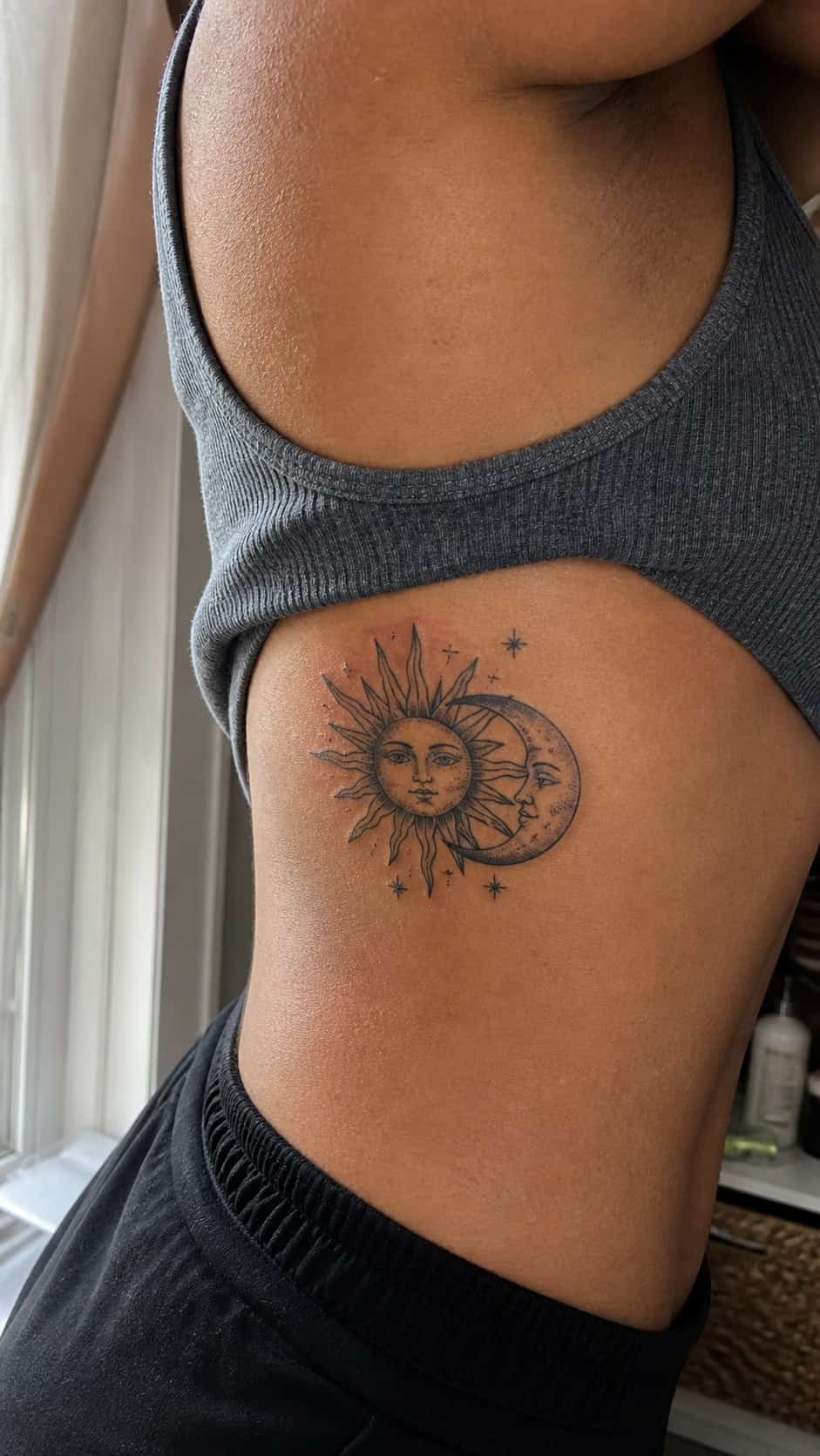 32 Stunning Rib Tattoos for Women 20 Healed sun and moon tattoo on a adult woman's side ribs, photographed in a natural relaxed documentary crop — study 1